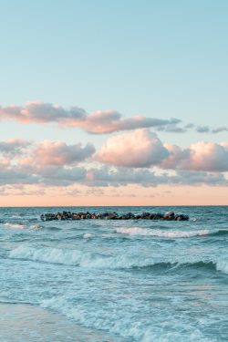A person walking on the beach with a surfboard